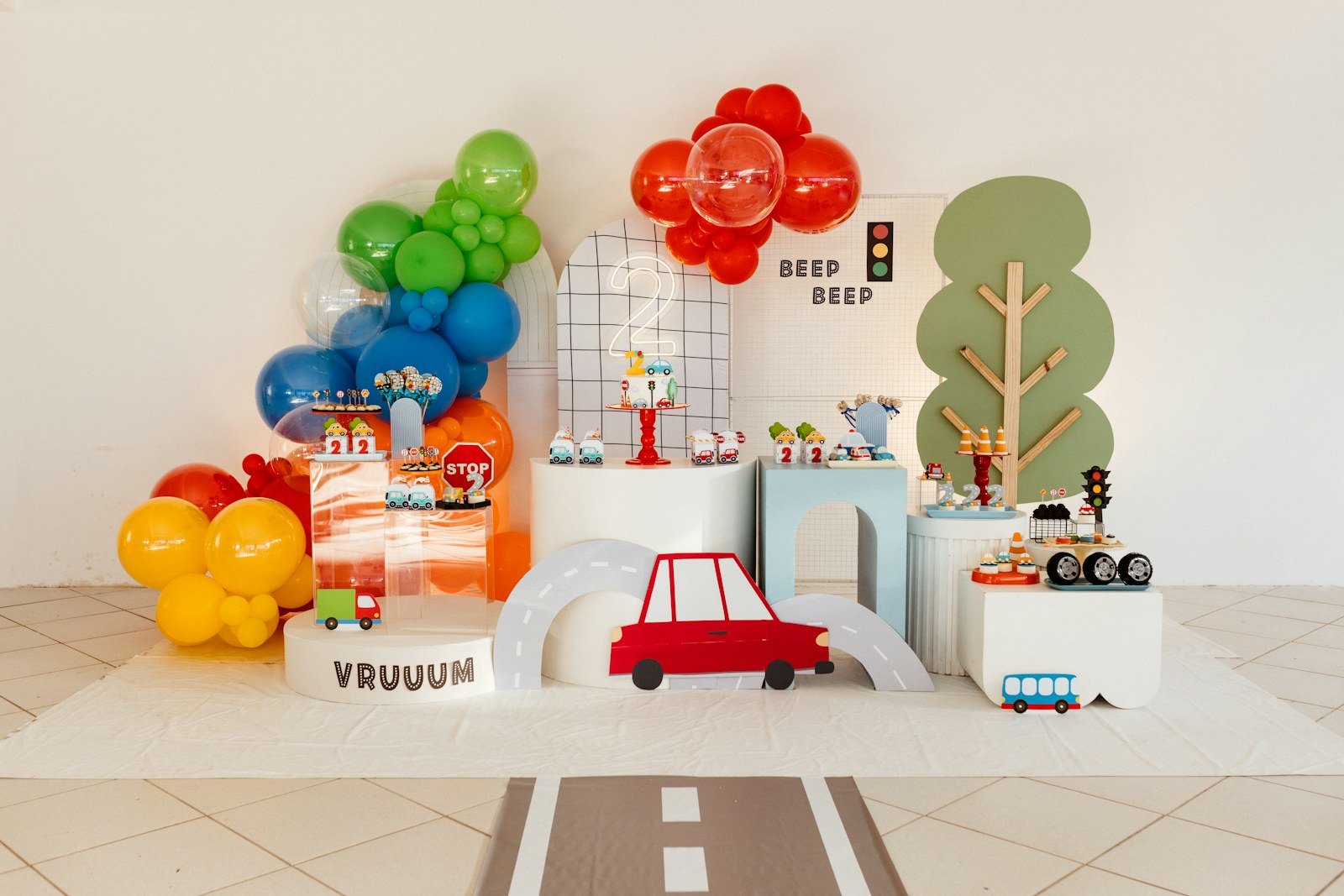 Colorful transportation-themed children's birthday backdrop with balloons and custom details